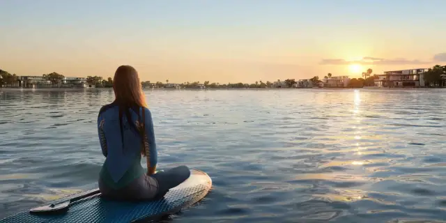 Mangrove-fringed mansion island at sunset, Downtown Abu Dhabi skyline in the distance