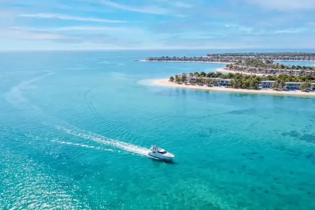 Aerial view of the island coastline with a passing boat