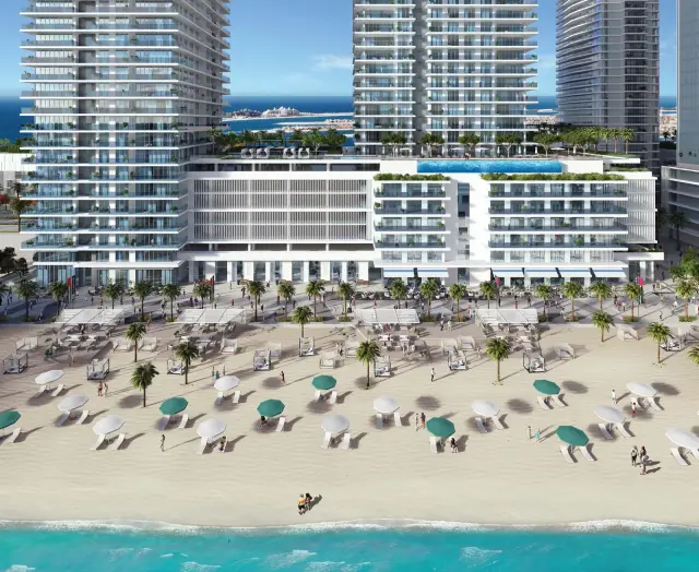 Sunrise Bay podium and towers behind a beach lined with parasols