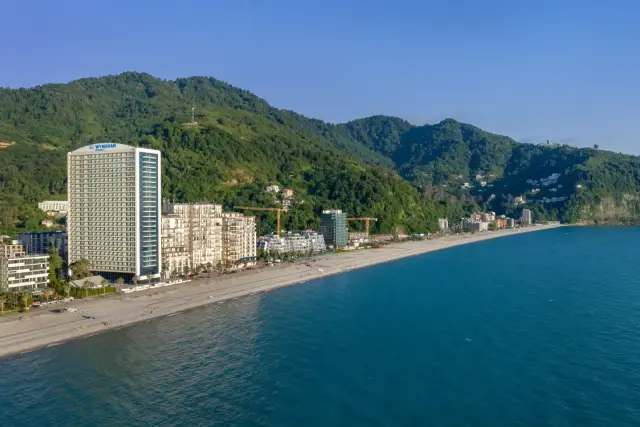 Wyndham Residences Batumi tower and coastline, mountain backdrop